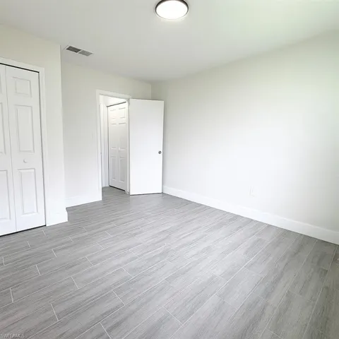 Unfurnished bedroom with wood tiled floors and a closet