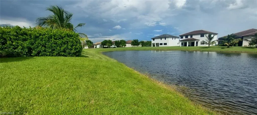 Expansive green lawn with mature landscaping and waterside frontage