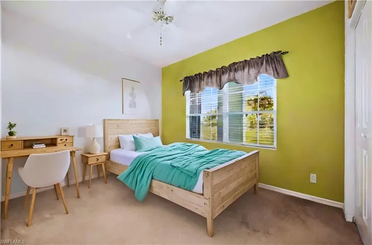 Carpeted bedroom with a closet and ceiling fan