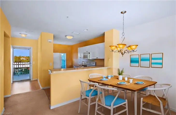 Carpeted dining space featuring a chandelier