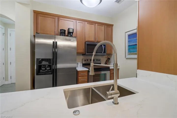 Kitchen featuring appliances with stainless steel finishes and light stone countertops