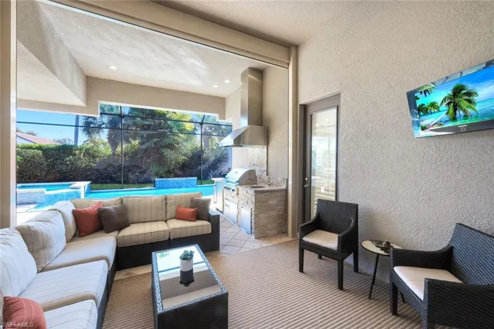 View of patio / terrace with an outdoor kitchen and area to lounge and a pool with connected hot tub