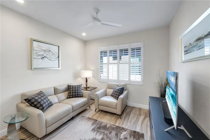 Living room featuring light wood-style floors, ceiling fan, and recessed lighting