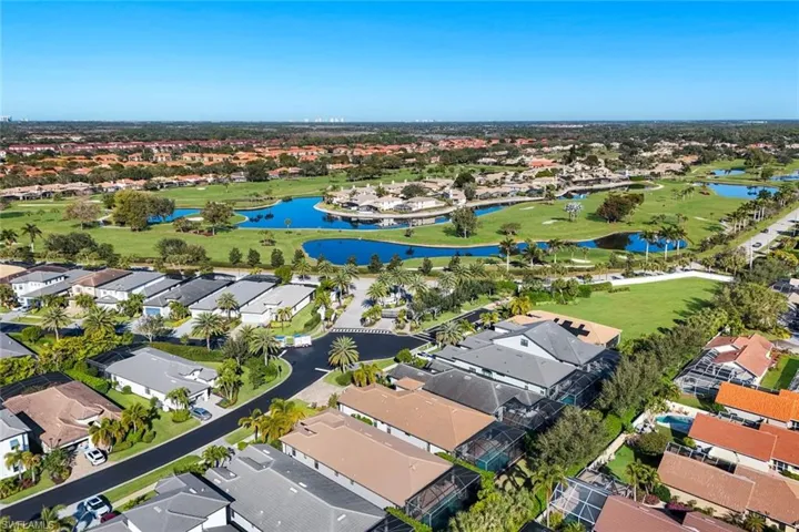 Aerial view of residential area with a nearby body of water and a golf course