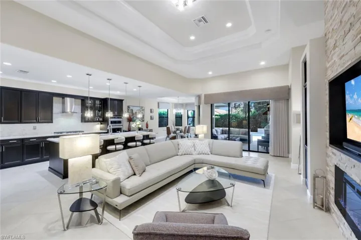 Living room with crown molding, recessed lighting, and a fireplace