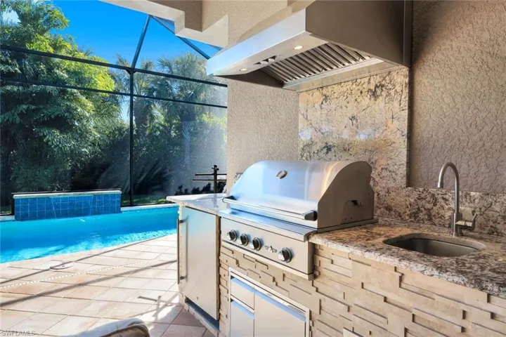 View of patio / terrace featuring an outdoor pool, glass enclosure, and area for grilling