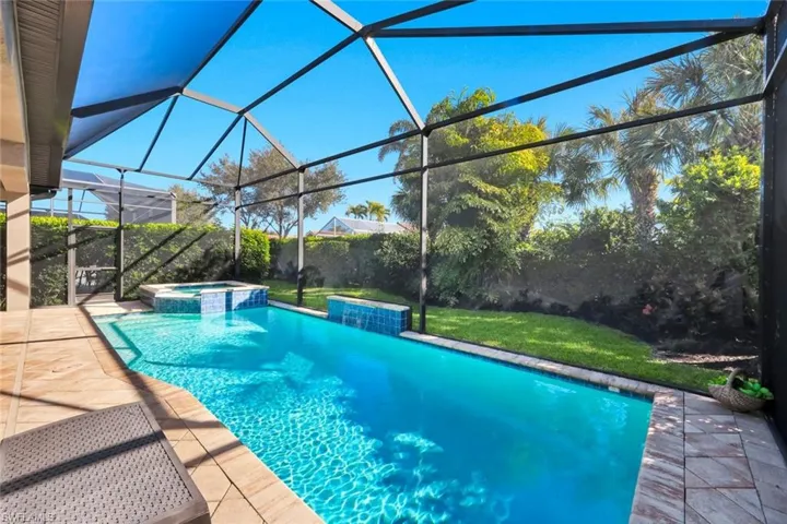 Relaxing pool / spa featuring a sunroom, a patio area, glass enclosure, and a fenced backyard