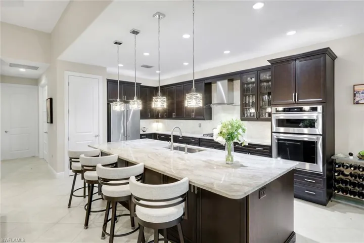 Kitchen featuring dark wood finish cabinets, glass fronted cabinets, stainless steel appliances, and backsplash