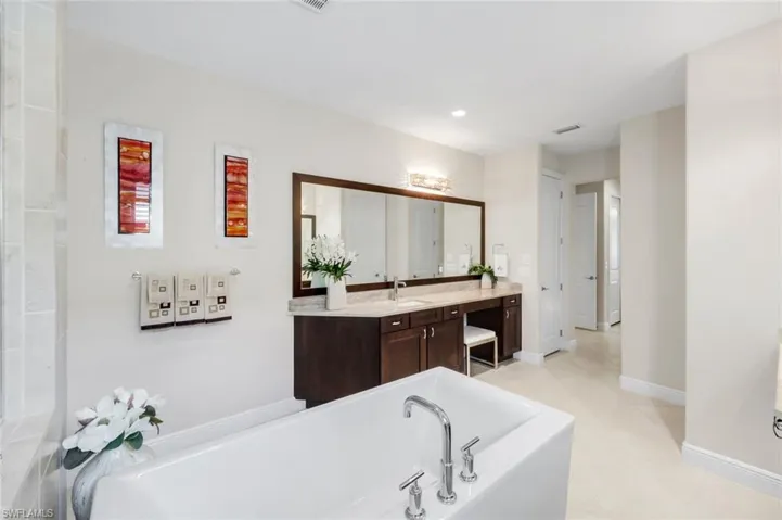 Full bathroom with a garden tub, vanity, light tile patterned floors, and recessed lighting