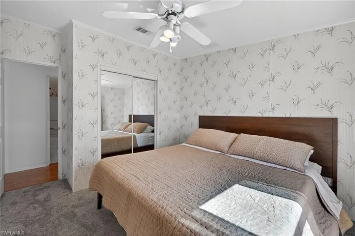 Bedroom with carpet floors, a closet, a ceiling fan, and a textured ceiling