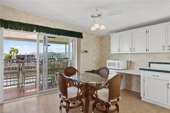 Breakfast area featuring wallpapered walls, a ceiling fan, a textured ceiling, and ornamental molding