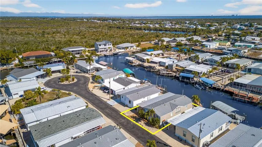 Aerial perspective of suburban area featuring a nearby body of water