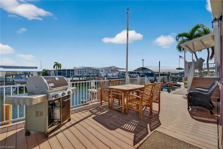 Deck with a water view, area for grilling, and outdoor dining area