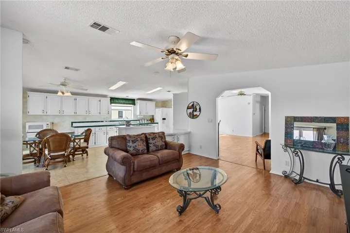 Family room featuring ceiling fan, a textured ceiling, and light wood-style flooring