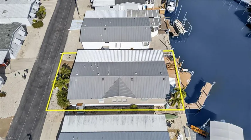 Aerial view of property and surrounding area featuring a large body of water and property boundaries highlighted