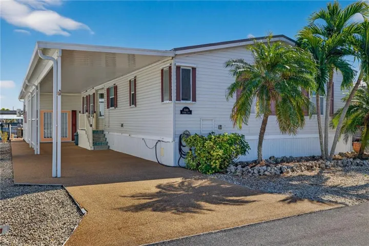 View of front facade with a carport and driveway