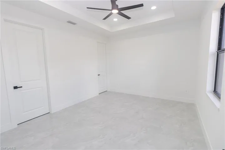 Bedroom with ceiling fan, recessed lighting, and a raised ceiling