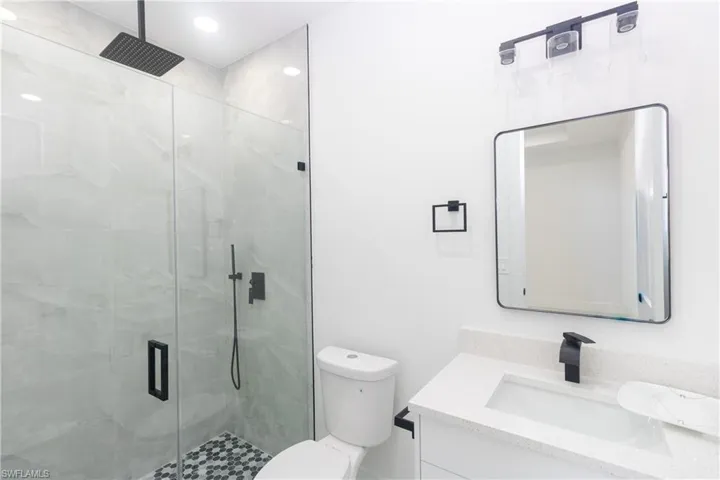 Full bathroom featuring vanity and a marble finish shower