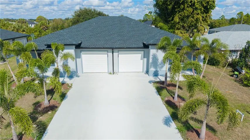 View of front of property featuring stucco siding, roof with shingles, driveway, and a garage
