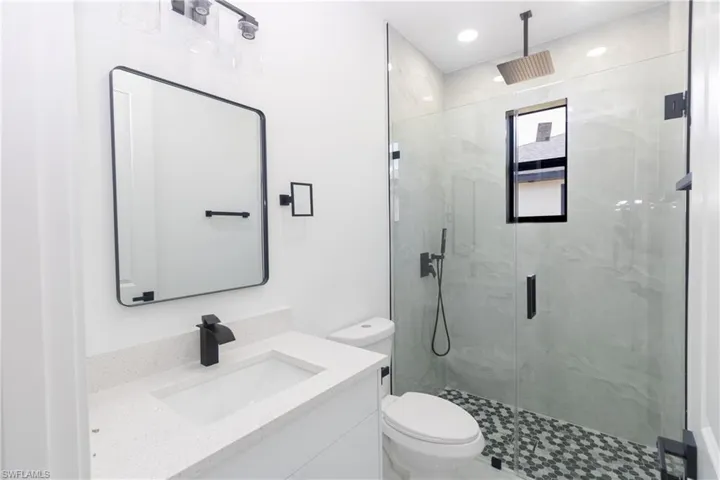 Full bath featuring vanity, a marble finish shower, and recessed lighting