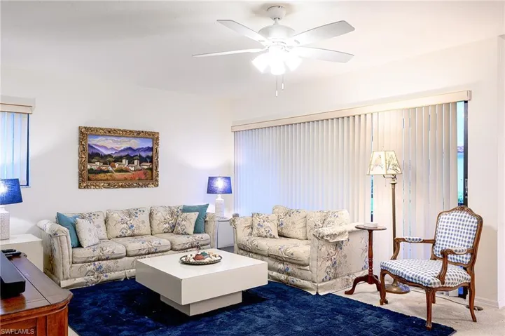 Carpeted living room with a wealth of natural light and ceiling fan