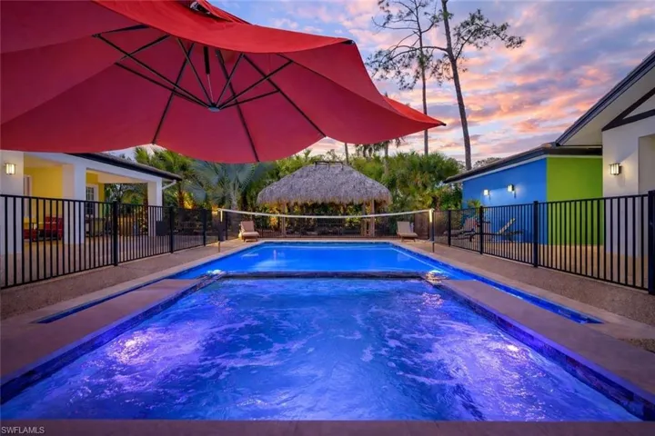 Pool at dusk with a patio area and a pool with connected hot tub