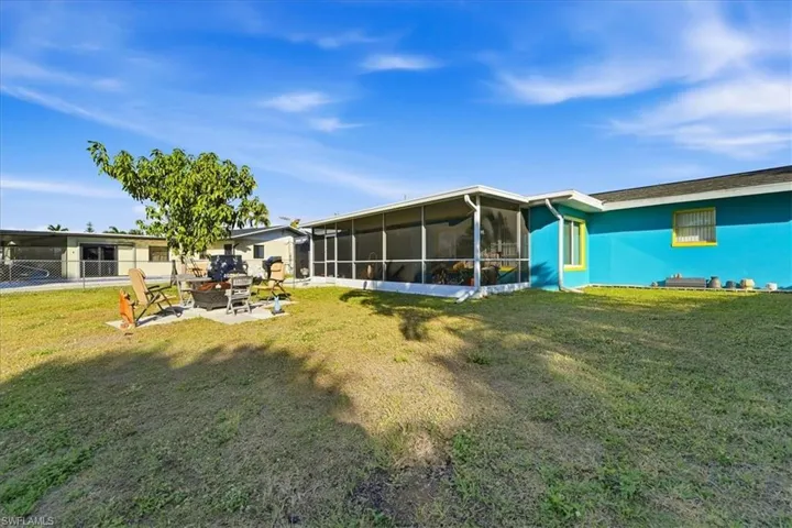 Rear view of house with a sunroom, a patio, and a fire pit