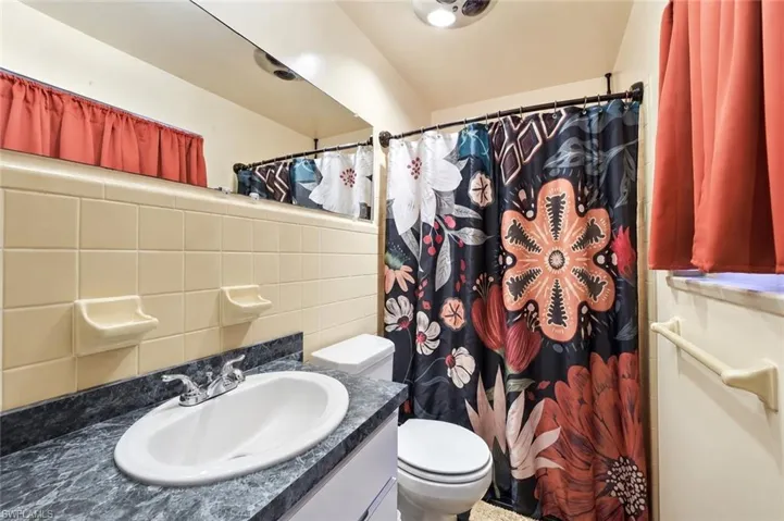 Bathroom vanity with integrated sink and chrome faucet, set against a tiled wall