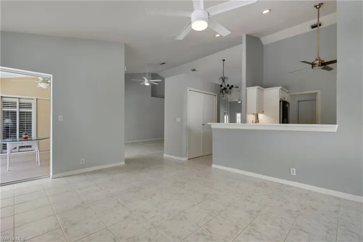 Unfurnished living room featuring ceiling fan, baseboards, recessed lighting, and high vaulted ceiling