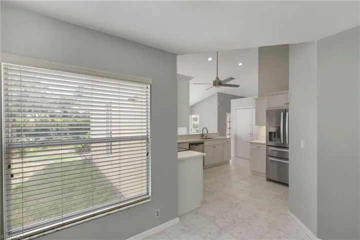 Kitchen featuring appliances with stainless steel finishes, light countertops, white cabinetry, a ceiling fan, and lofted ceiling