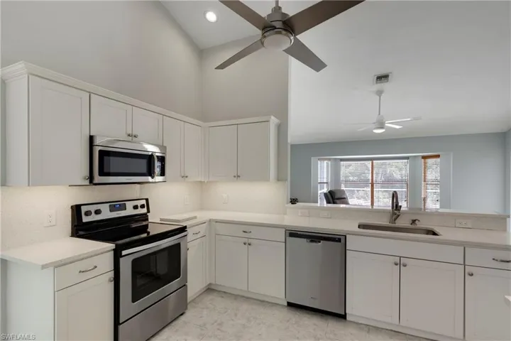 Kitchen featuring appliances with stainless steel finishes, ceiling fan, a sink, decorative backsplash, and recessed lighting