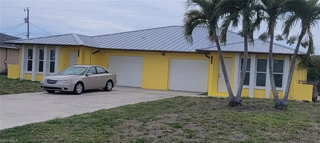 Duplex exterior Freshly Painted and a metal rooplex property with a bright yellow f