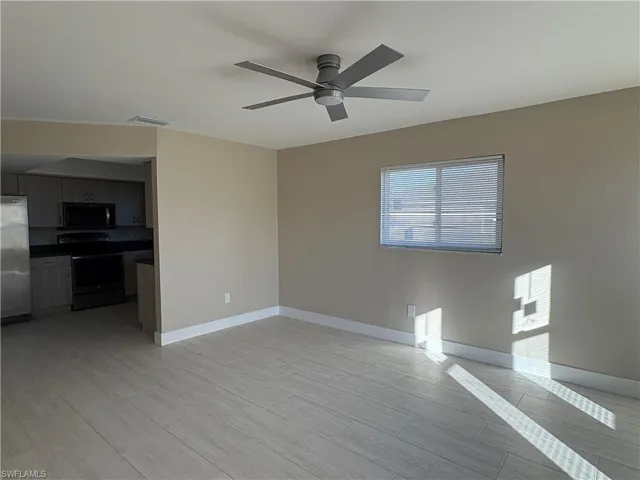 Unfurnished living room with wood finish floors and ceiling fan