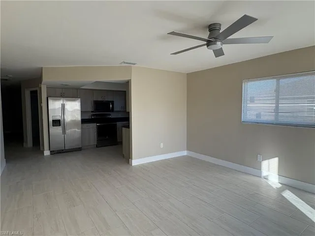 Unfurnished living room with ceiling fan and wood finish floors
