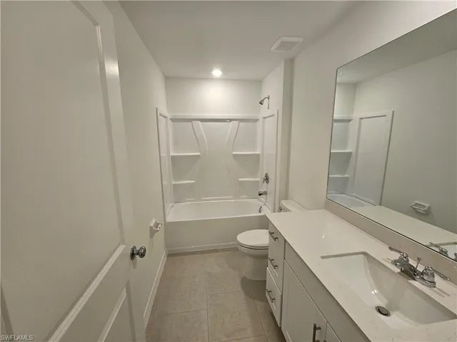 White vanity with quartz-finish countertop and undermount sink