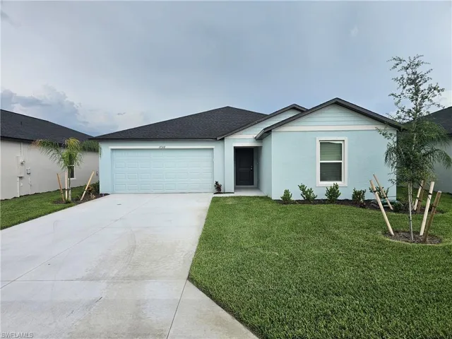 Single-story residence featuring a light blue stucco and siding exterior