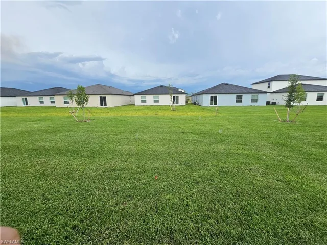 Expansive green space featuring newly planted trees