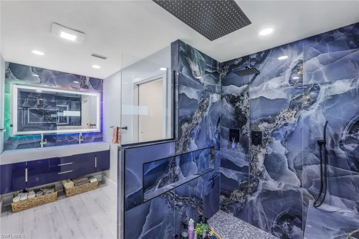 Bathroom featuring tile walls, a shower, vanity, and hardwood / wood-style floors