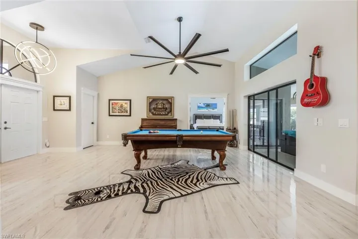 Game room with lofted ceiling, pool table, and light hardwood / wood-style floors