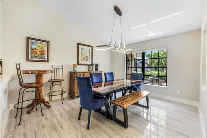Dining space featuring lofted ceiling, light hardwood / wood-style flooring, and a chandelier