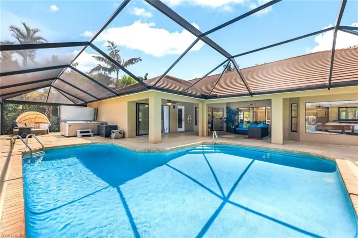 View of swimming pool with ceiling fan, outdoor lounge area, glass enclosure, and a patio area