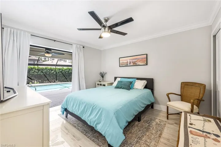 Bedroom featuring ceiling fan, light wood-type flooring, ornamental molding, and access to outside