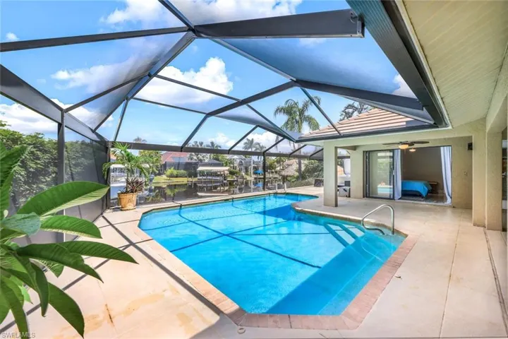 View of pool featuring a lanai, ceiling fan, and a patio area