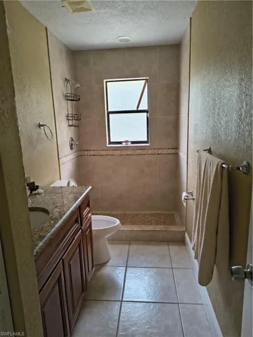 Bathroom featuring a walk-in shower with tiled walls and a decorative accent band
