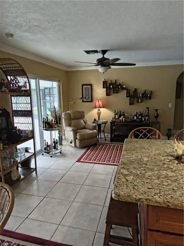 Spacious interior featuring tile flooring, a ceiling fan, and sliding glass doors