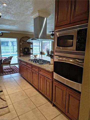 Kitchen featuring a large central island with granite countertops and a gas cooktop