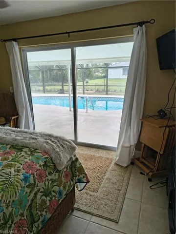 Sliding glass doors open to a screened pool area with concrete decking