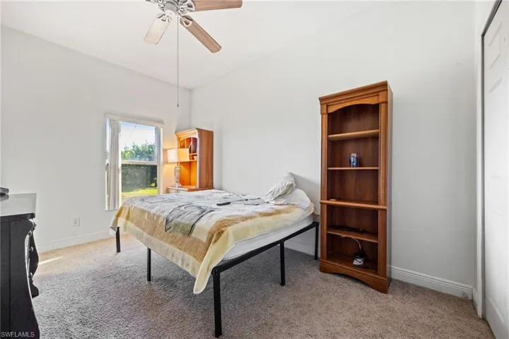 Bedroom with a ceiling fan and light carpet