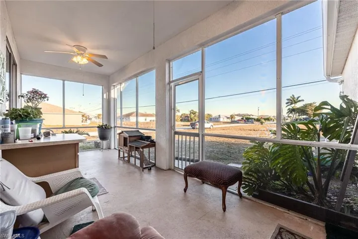 Sunroom / solarium with a ceiling fan and a residential view