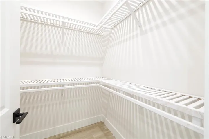 Master bedroom closet Walk in closet featuring wood-type flooring